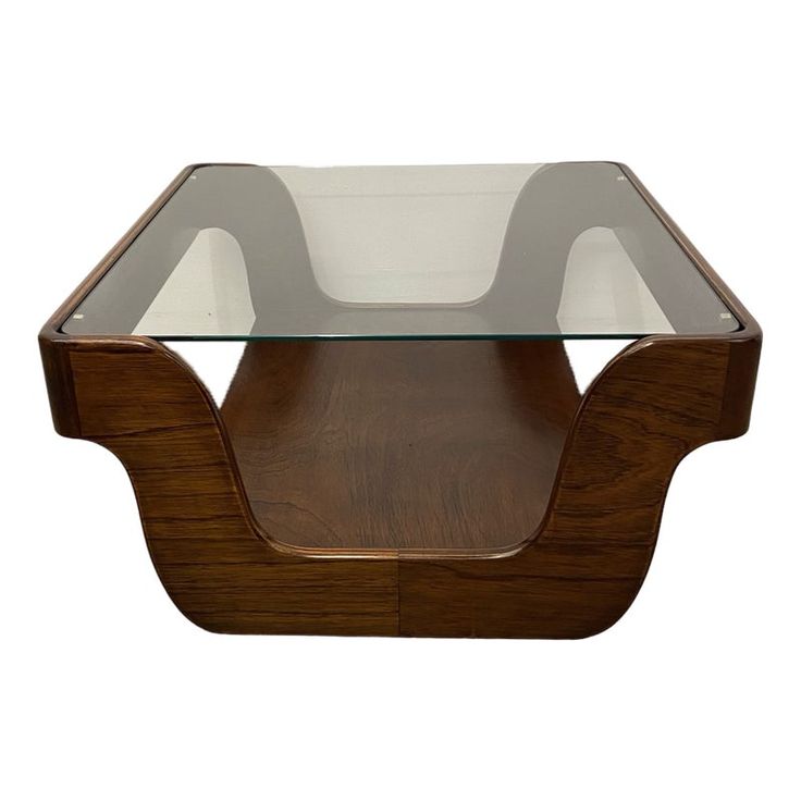 a glass and wood coffee table with an unusual shaped design on the top, against a white background