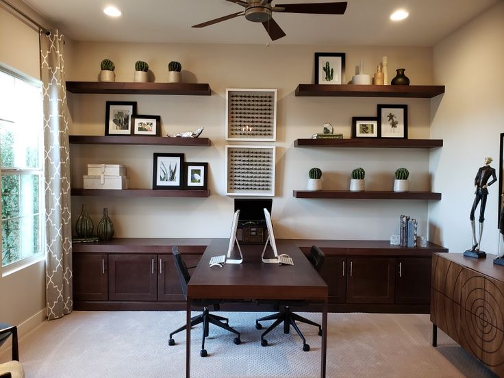 a home office with shelves, desk and ceiling fan in the middle of the room