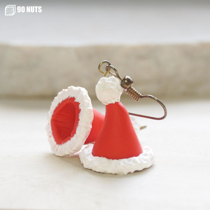 a red and white santa hat keychain with a fishing hook attached to it