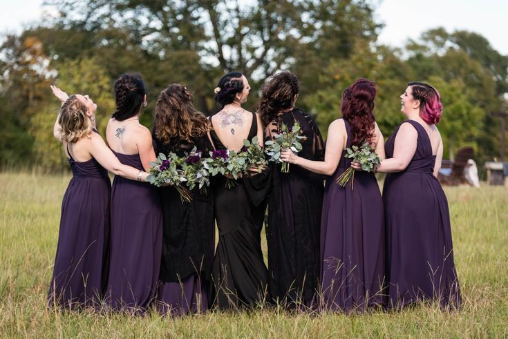 a group of women standing next to each other in a field