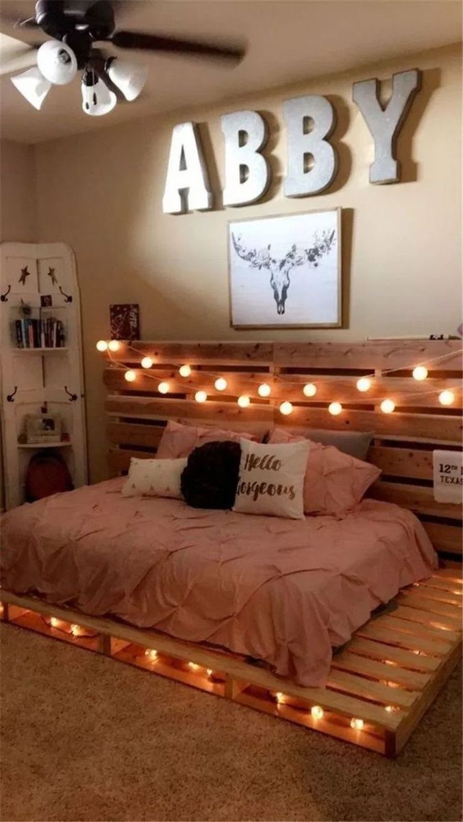 a bed made out of pallets with lights on the headboard