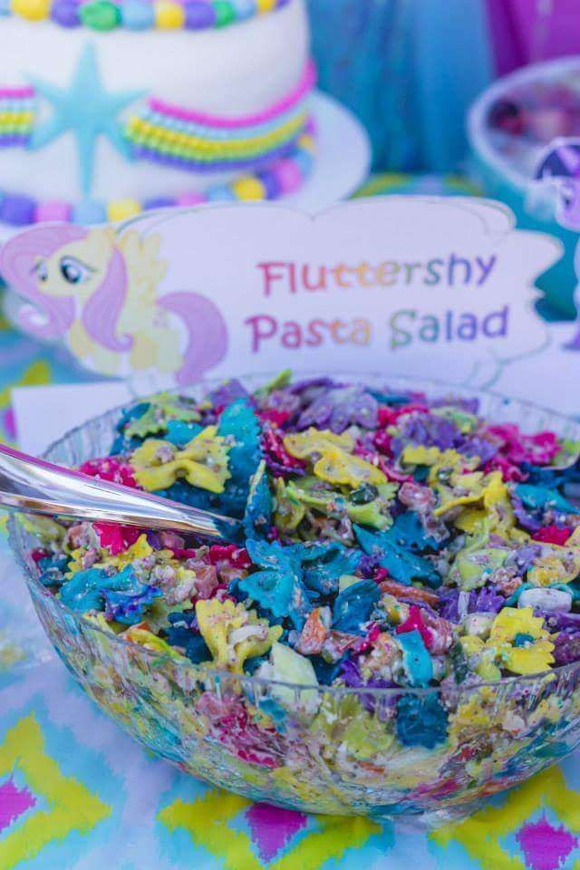 a bowl filled with colorful cereal and sprinkles next to a sign that says flutterershy pasta salad