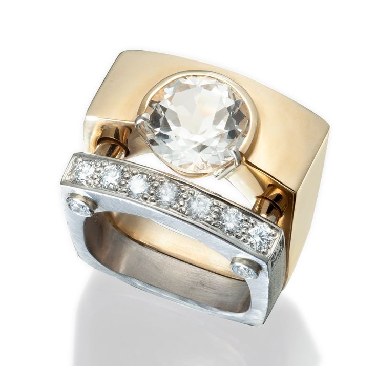 two tone gold and silver ring set with an oval cut crystal surrounded by small diamonds