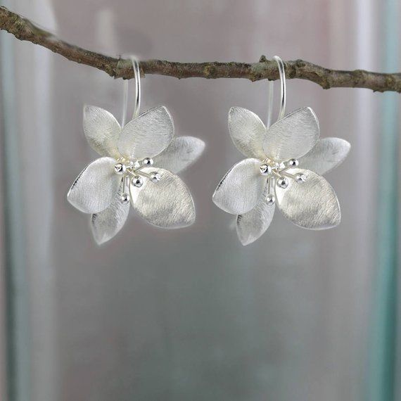 These flower earrings are just that right balance between literal and abstract. A gentle satin finish gives them added shimmer and they balance perfectly on the long ear wire hook.  Size: 25 X 30 mm (drop)  All of my jewellery comes wrapped in tissue paper and packed in a pretty gift Elegant Sterling Silver Flower Earrings For Spring, Delicate Silver Earrings With Flower Charm, Delicate Silver Flower Earrings For Anniversary, Silver Flower Earrings For Spring, Silver Flower Shaped Earrings For Spring, Silver Flower Earrings With 3d Flowers As Gift, Silver Flower Earrings With 3d Flowers For Gift, Silver 3d Flower Earrings, Silver 3d Flower Earrings For Gifts