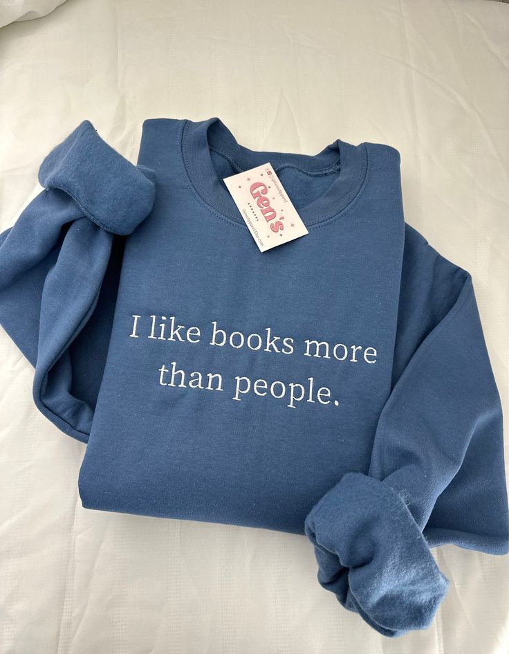 Declare your bookish priorities with our "I Like Books More Than People" embroidered sweatshirt, the ultimate statement piece for any book lover. This minimalist book sweatshirt, designed as the perfect book club gift, seamlessly merges comfort and literary charm, celebrating your passion for the written word in style. Color in example is Indigo Blue * 50% cotton, 50% polyester * Pre-shrunk * Classic fit * 1x1 athletic rib knit collar with spandex * Air-jet spun yarn with a soft feel and reduced Books Minimalist, Bookish Sweatshirts, Book Merch, Very Deep Quotes, Girly Christmas Gifts, Minimalist Book, Stocking Stuffers For Her, Bookclub Gifts, Book Clothes