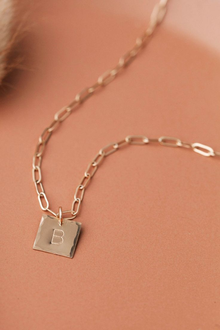 Bossy, edgy and bold! This charm necklace is sure to turn heads. With a hammered edge detail and one of our boldest chains, this necklace will become your new statement piece. Square Pendant Necklaces With Charms, Everyday Square Pendant Charm Necklace, Everyday Personalized Square Pendant Charm Necklaces, Everyday Personalized Square Pendant Charm Necklace, Personalized Initial Necklace With Square Pendant, Personalized Square Pendant Jewelry, Hand Stamped Necklace, Square Pendant, Layering Necklace