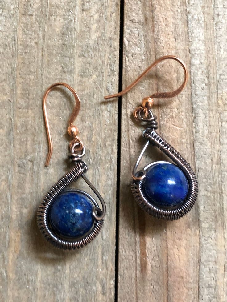 Copper wire has been carefully woven around a 10mm Lapis Lazuli bead to make these cute drop earrings and then suspended from a copper ear wire. The drop is approx. 1 inch in length. These earrings were inspired by Cheryl St. Pierre. Artisan Blue Drop Earrings, Adjustable Blue Wrap Earrings For Gift, Handmade Round Lapis Lazuli Earrings, Blue Wire Wrapped Dangle Earrings, Blue Metal Teardrop Earrings Gift, Blue Wire Wrapped Teardrop Earrings Gift, Handmade Sapphire Teardrop Earrings, Handmade Teardrop Sapphire Earrings, Wire Wrapped Lapis Lazuli Dangle Earrings