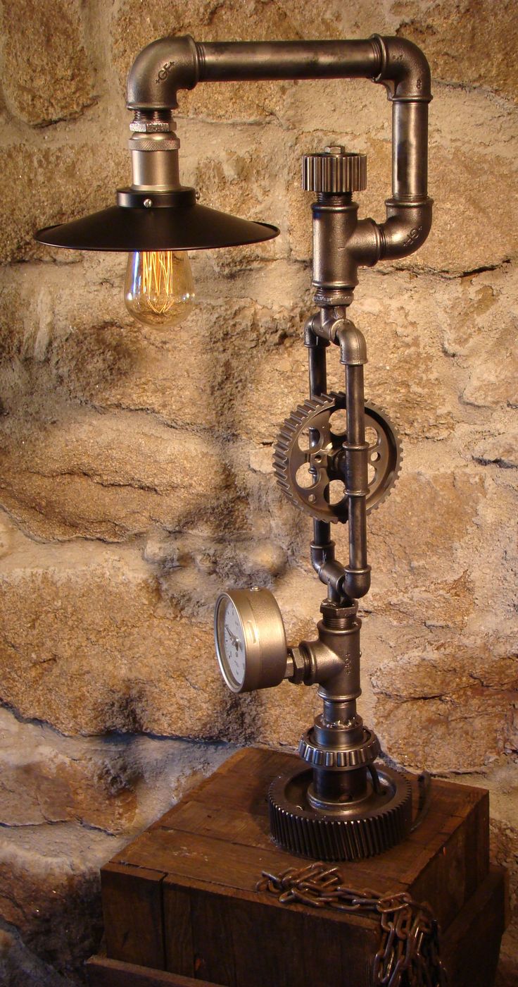 an old fashioned steam engine lamp on top of a wooden box in front of a stone wall