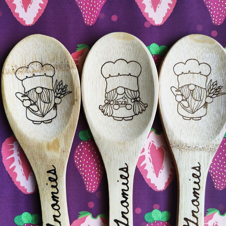 three wooden spoons with different designs on them