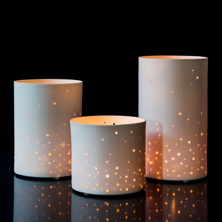 three lit candles sitting on top of a black table next to each other and one candle in the middle