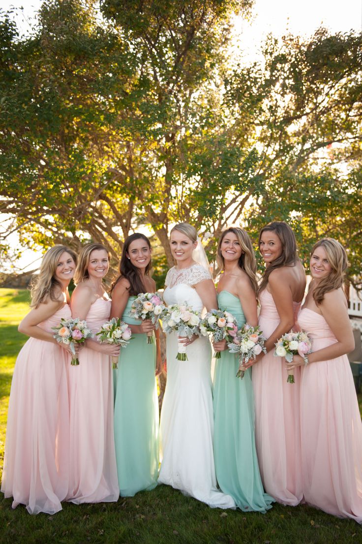 a group of women standing next to each other on top of a lush green field