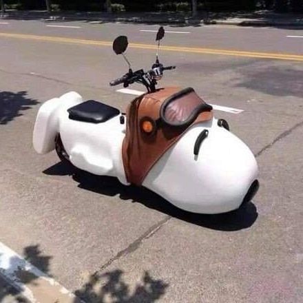 a white and brown motorcycle is parked on the side of the road with its seat down