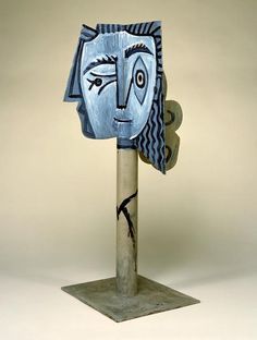 a metal sculpture with a blue face on it's head and an eye in the middle