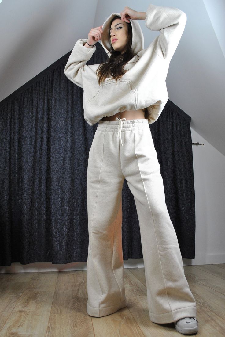 This is a super cool pair of modern tracksuit pants. Very flattering, trendy loose flared cut. Elasticated waist with inside drawstring. It has got a stitched crease for modern edgy look.  The color is very flattering to any complexion as it is glowy warm off white, natural.  The fabric is very high quality, made in Poland, with added hemp for its incredible properties (strength, absorbency, breathability, antimicrobial, sustainability). Here is a matching hoodie: https://www.etsy.com/listing/16 White Flared Wide Leg Cotton Pants, White Flare Wide Leg Cotton Pants, Beige Wide Leg Sweatpants For Streetwear, Beige Wide-leg Sweatpants For Streetwear, Flare Cotton Pants For Streetwear, Beige Relaxed Fit Wide Leg Sweatpants, Beige Relaxed Fit Wide-leg Sweatpants, Beige Wide Leg Relaxed Fit Sweatpants, Cream Cotton Sweatpants For Fall