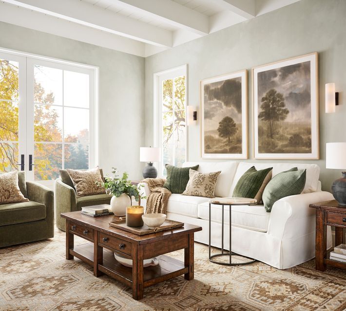 a living room with two couches, a coffee table and pictures on the wall