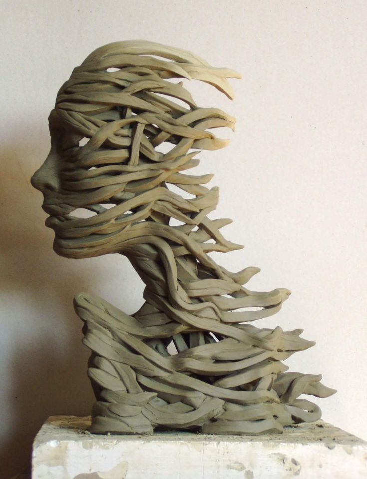 a sculpture made out of clay sitting on top of a white table next to a wall