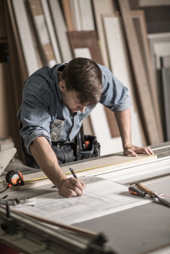 a man is working on a project in his workshop with some woodworking equipment around him