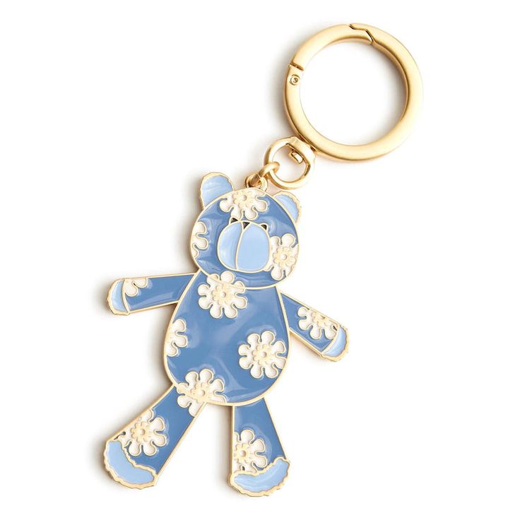 a blue and white teddy bear keychain with flowers on it's side