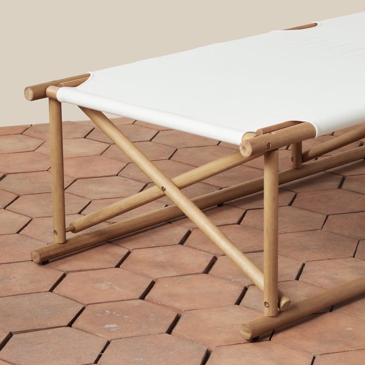 a white table sitting on top of a red brick floor next to a wooden frame