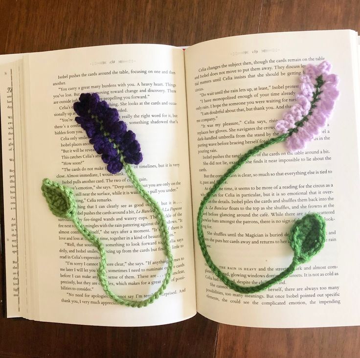 an open book with crocheted flowers on it