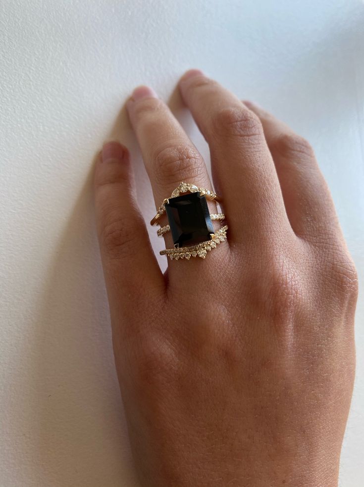 The big sister to our beloved Onyx Ring. A 5.5ct emerald cut Black Onyx is set into our signature claw prongs for a dramatic effect. The subtle, flat quarter band with 0.09tcw of Diamonds gives this piece its modern feel with just the right amount of shine. This ring will certainly turn heads! Treat with love due to the center stone softness. Band width, 1.5mm. Pictured on a size 4 finger. Can't wait? Check out our Ready To Ship pieces or send us a message! Ring Black Stone, Dark Wedding Theme, Onyx Engagement Ring, Claw Prong, Black Onyx Ring, Put A Ring On It, Dress Rings, Onyx Ring, Baguette Diamond