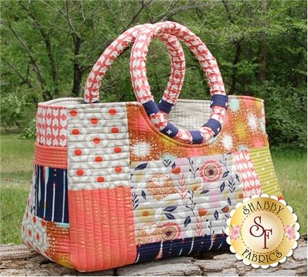 an orange and white bag sitting on top of a wooden table in front of trees