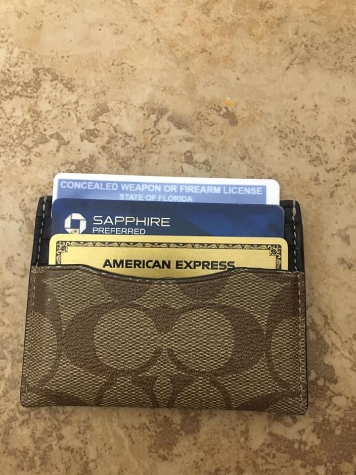 a wallet with credit cards in it sitting on a counter top next to an american express card case