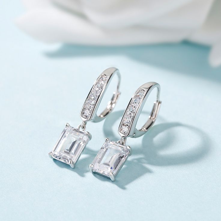 Sparkling and stunning, these earrings will capture your heart at first sight. Crafted in sterling silver, each earring features an emerald cut stone sparkling crazily on your ear, while a glistening hoop setting add extra sparkle to the design. This pair of earrings will show an charming look on your ears. Treat yourself or surprise her with this masterpiece.Carat Weight: 1 ctStone Size: 3*5 mmStone Type: Jeulia® StoneNumber of Stones: 2 Stone Color: Diamond WhiteStone Shape: RadiantCarat Weigh Silver Rectangular Cubic Zirconia Earrings, Elegant Rectangular Crystal Earrings, Rectangular Crystal Earrings For Gifts, Elegant Silver Rectangular Diamond Earrings, Elegant Rectangular Sterling Silver Hoop Earrings, Elegant Sterling Silver Rectangular Hoop Earrings, Elegant Silver Rectangular Earrings, Silver Baguette Cut Cubic Zirconia Earrings, Silver Baguette Cut Fine Jewelry Earrings