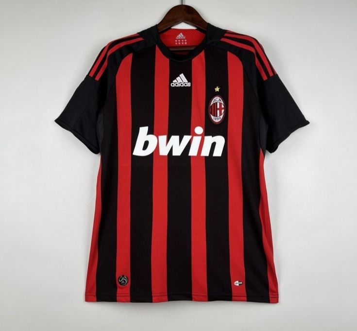 a black and red soccer jersey hanging on a hanger