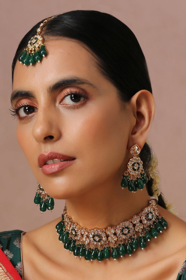 Gold finish floral shaped choker with green kundan embellishment. Comes with earrings and maangtikka.
Component: 1 Choker, Pair Of Earrings, Maangtikka
Type: Kundan
Composition: Brass
Color: Green
Other Details: 
Pearl drops
Dimensions L x W (in inches):
Necklace: 14 x 13
Earrings: 2 x 1
Weight (in gms): 310
Closure:
Necklace: Pull out-drawcord
Earrings: Push back clasp
Maangtikka: Fish hook
 - Aza Fashions Indian Choker Necklace, Kundan Jewellery Bridal, Gray Necklace, Green Accessories, Color Necklace, Metal Necklace, Choker Set, Green Jewelry, Kundan Necklaces