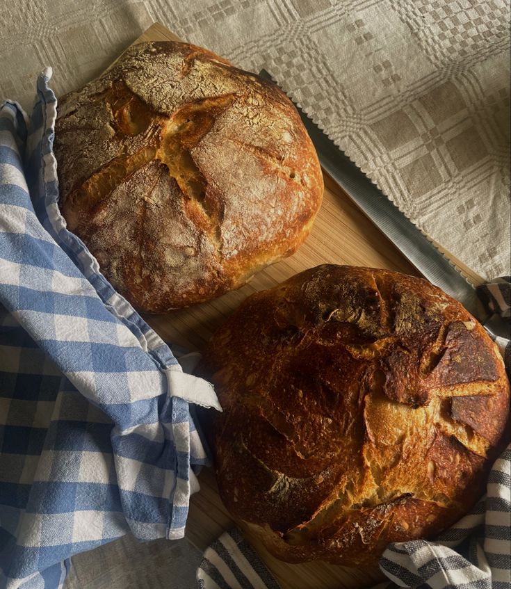 two loaves of bread sitting on top of a cutting board