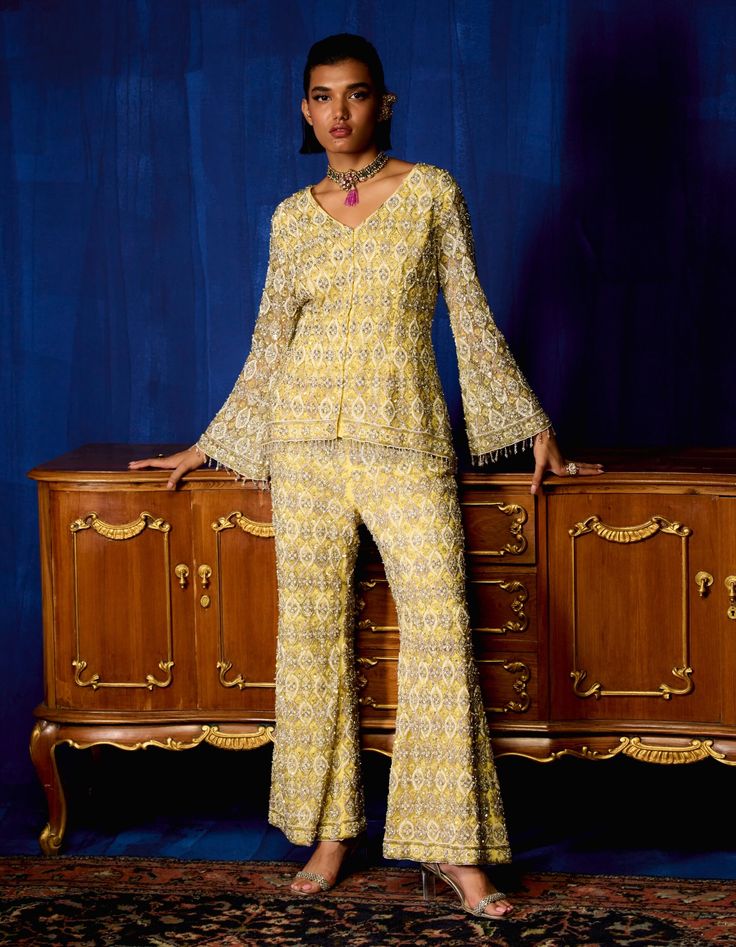 Embrace elegance with this yellow gold and silver embroidered jacket and pant set, showcasing a perfect balance of modern style and traditional craftsmanship. Paired with a net cheetah-patterned dupatta, this ensemble exudes a bold yet sophisticated charm, ideal for special occasions where you want to stand out with confidence. Elegant Pant Set With Zari Work For Reception, Elegant Pant Set With Zari Work And Long Sleeves, Festive Embellished Yellow Salwar Kameez, Elegant Designer Yellow Anarkali Set, Elegant Yellow Anarkali Set For Designer Wear, Elegant Long Sleeve Pant Set With Zari Work, Elegant Yellow Floor-length Palazzo Set, Elegant Yellow Designer Wear Sets, Elegant Yellow Salwar Kameez For Reception