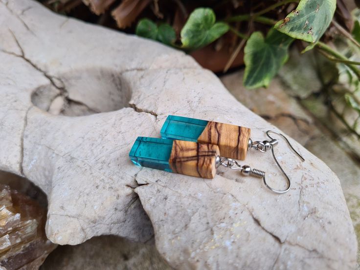 Unique Rectangle earrings made of olive wood and epoxy resin in blue color, homemade from dried olive wood and epoxy. Made from the ancient olive wood tree (more than 200 years old). Dried wood. Made in the home craft. Shaped perfectly. Each piece is unique. Comes in a decorative box, ready as a gift. Its main color is blue,  but other colors are possible ..  Materials : Olive Wood Resin  the dimensions of the earrings: Drop length 4cm Length          2.5cm Width            1 cm  Your order will be packaged in a beautiful box, ideal for gifts, which are carefully packed for delivery. If you have any questions about these Earrings, please contact me and I will get back to you as soon as possible. Rectangle Earrings, Wood Tree, Wood Resin, Olive Wood, Wood Jewellery, Girlfriend Gifts, Decorative Boxes, Jewelry Earrings Dangle, Dangle Drop Earrings