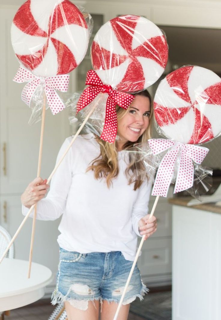 a woman holding lollipops in her hands and posing for the camera with them