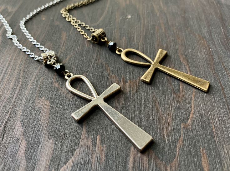 This handmade necklace features a faceted black glass bead and large ankh charm. Wear it layered with other necklaces for your own personal statement. Product details Plated metals. Faceted black glass bead. Choose your stainless steel or bronze chain length with matching clasp. Check out more necklaces here: https://www.etsy.com/shop/AnEnchantingCreature?ref=seller-platform-mcnav&section_id=21978338 VISIT MY SHOPS HERE * http://www.etsy.com/shop/HappyCatHouse * http://www.Etsy.com/shop/AnEn Ankh Shaped Black Metal Necklace, Black Ankh Necklace In Metal, Symbolic Ankh Necklace Adjustable, Symbolic Ankh Necklace, Black Ankh Metal Jewelry, Silver Ankh Necklace In Brass, Bohemian Ankh Necklace In Metal, Handmade Metal Ankh Necklace, Adjustable Ankh Black Necklace