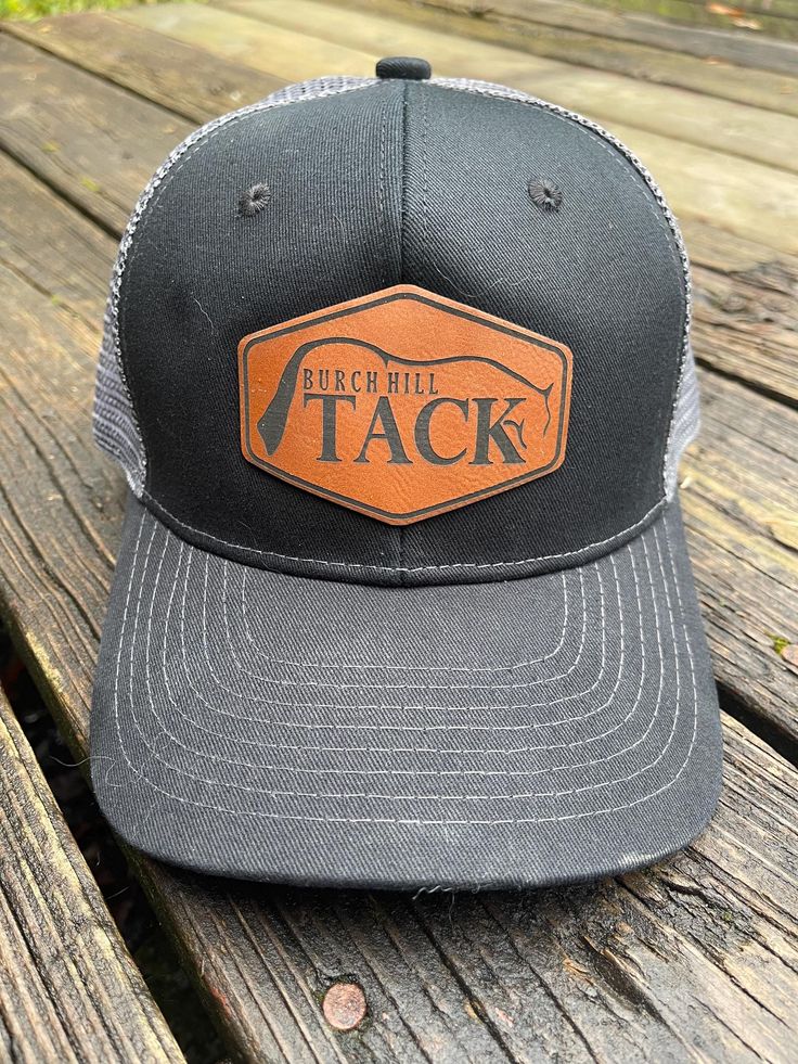 BH Leather Branded patch trucker hat. Ships in 1-2 business days. The back of the hat is a snapback. Gray Snapback Hat With Logo Patch And Curved Brim, Gray Trucker Hat With Logo Patch, Gray Trucker Hat With Logo Patch And Curved Bill, Gray Outdoor Hat With Logo Patch, Black Snapback Hat With Leather Patch For Outdoor, Black Hat With Leather Patch, One Size Fits Most, Black Hats With Leather Patch, Black Hat With Leather Patch One Size, Black Hat With Leather Patch