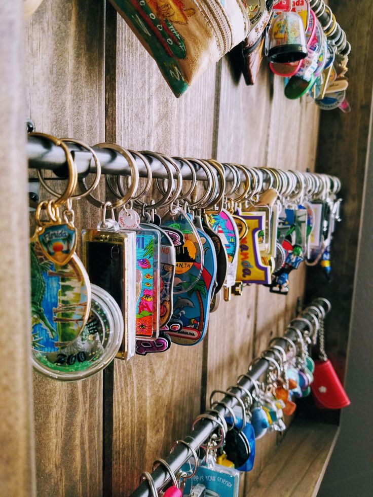 a wooden wall with many key chains hanging from it's sides and various magnets attached to the hooks