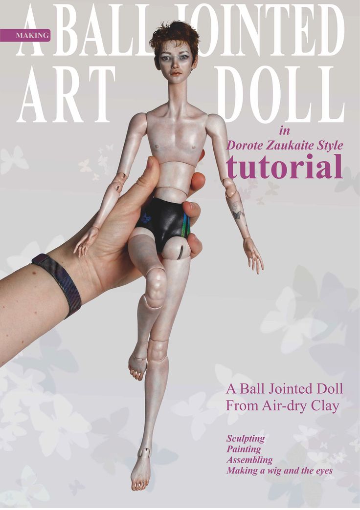 a hand holding a doll in front of the cover of a magazine with an image of a