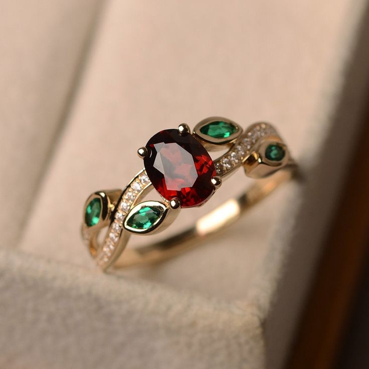 This ring features a 6*8mm oval cut natural garnet and marquise cut lab emerald. Customization is available. It is made by hand, and it will take about 7 days to finish the ring after your payment is completed. Main stone: Natural garnet Main stone weight: Approx 1.73 ct Metal type: 14k yellow gold Accent stone: lab emerald and cz Customization is available, I also can make it with 14k solid gold (white or yellow or rose) and diamond accent stone, just feel free to contact me. Any question, just Garnet Wedding Rings, Ruby Wedding Rings, Garnet Wedding, Smaragd Ring, July Birthstone Ring, Leaf Engagement Ring, Ruby Wedding, Ruby Engagement Ring, Ring Stacking