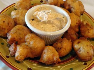 a plate filled with tater tots covered in ranch dip on top of it