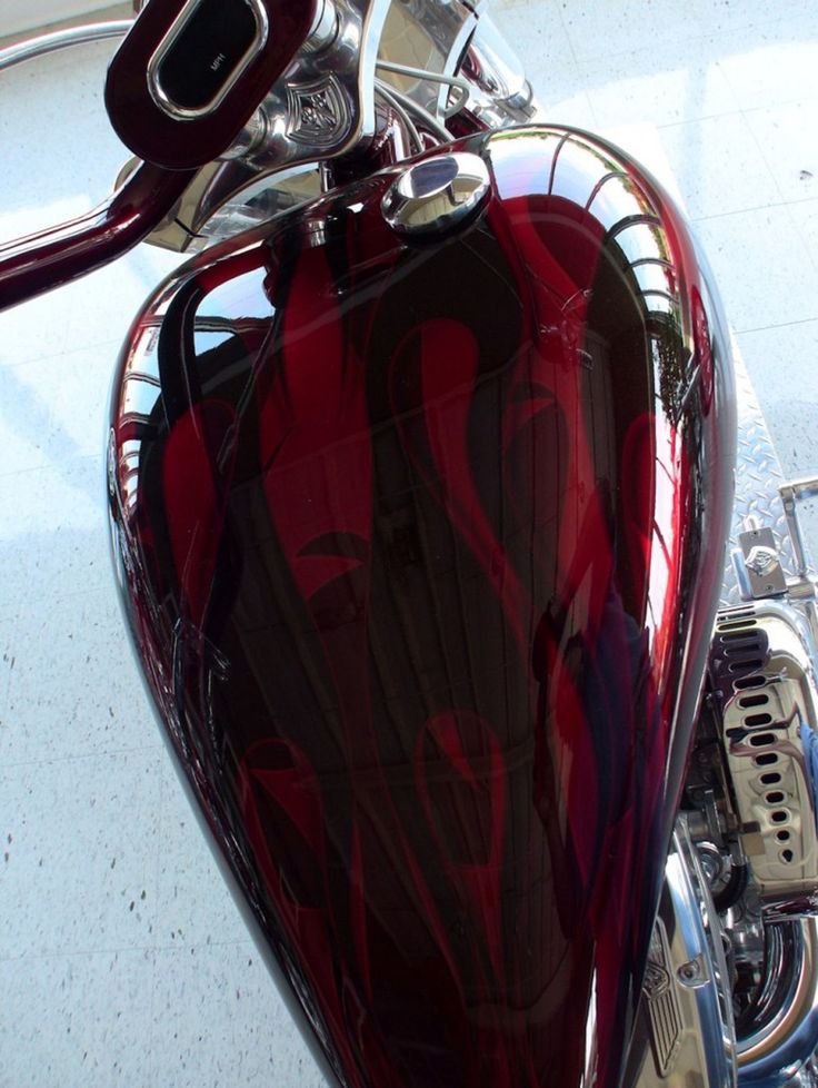 a red motorcycle parked on top of a cement floor