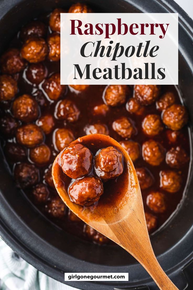 a wooden spoon filled with meatballs in a crockpot on top of a table