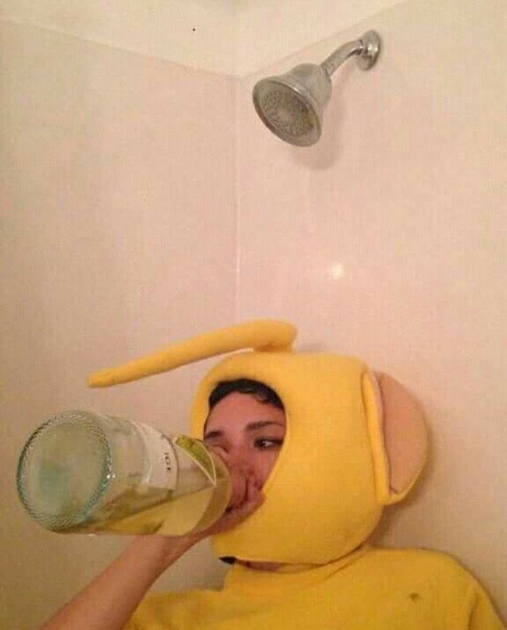 a woman in a yellow shirt drinking from a water bottle while wearing a pikachu costume