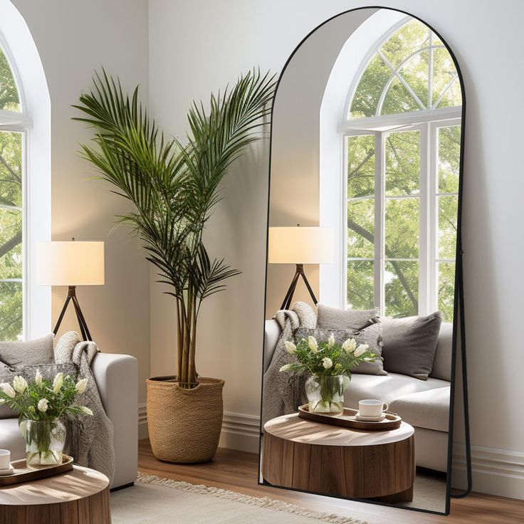 a living room filled with furniture and a large mirror next to a plant on top of a table