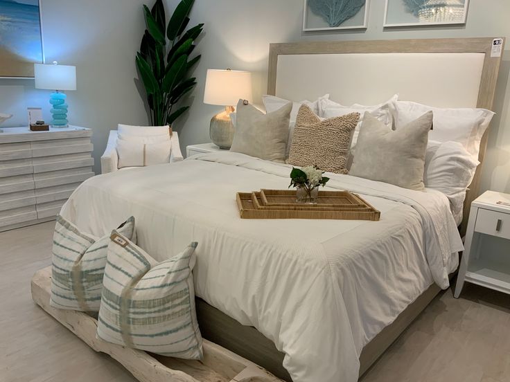 a bed with white sheets and pillows on top of it next to two nightstands