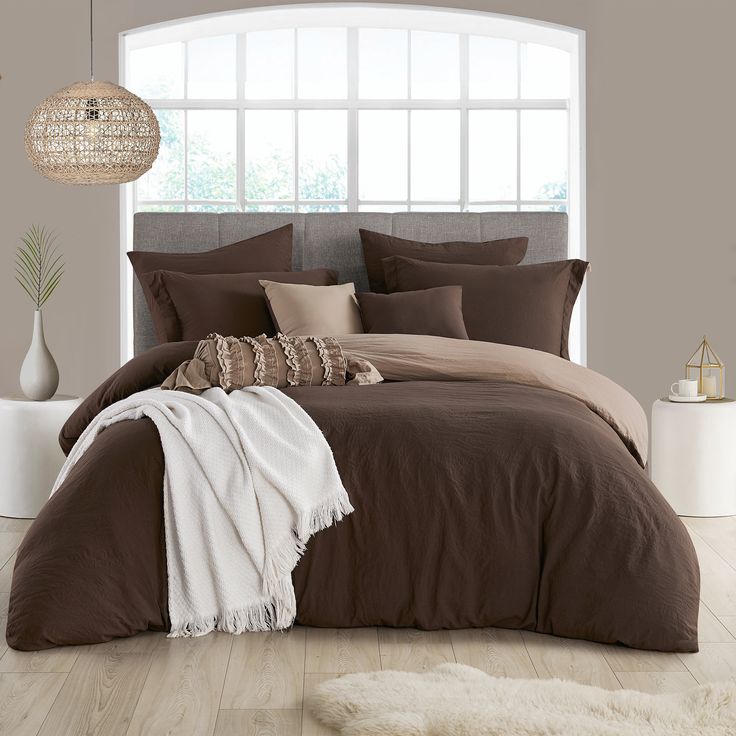 a large bed in a bedroom with brown and white comforter on top of it