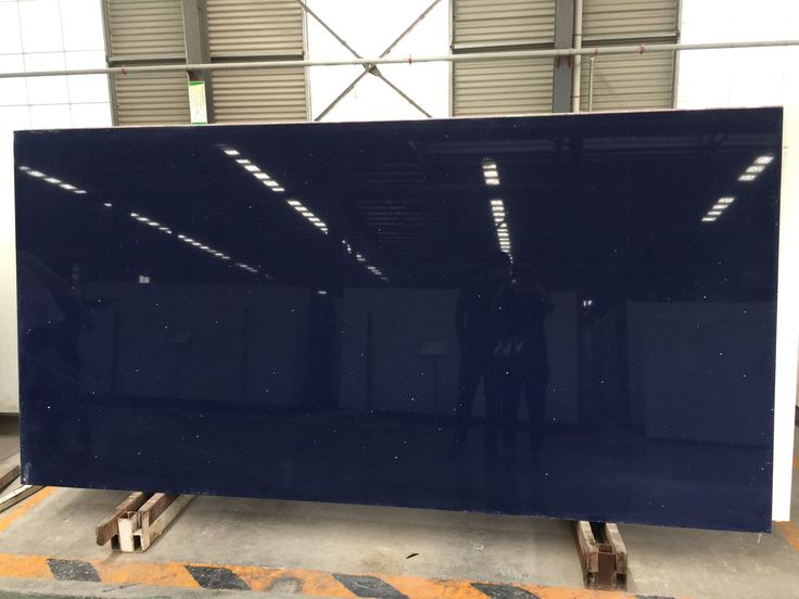 the large blue screen is being worked on in a factory room with workers standing behind it