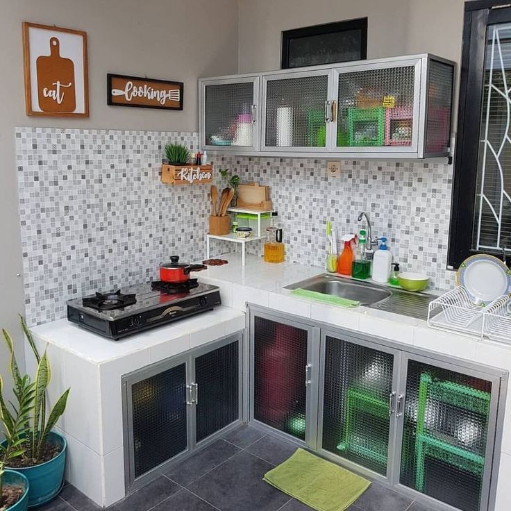 a small kitchen with lots of cabinets and appliances on the counter top, as well as a potted plant