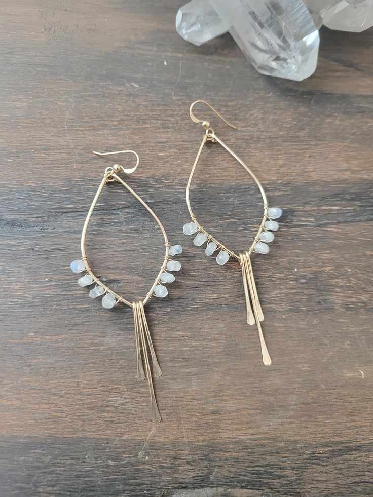 So in love with these Moonstone Tulip Earrings! These beauties are abstract art pieces of tulips that you can wear and take with you on your adventures! They are the perfect addition to your Spring/Summer jewelry and they go with just about anything! They are available in Sterling Silver and 14K Gold Filled. Each piece is hand formed and hammered for texture and shape. Four beautiful Moonstone Gems are wire wrapped up each side of the earring. The length of the earrings are just a tad over 3 in. Adjustable Teardrop Bohemian Wrap Earrings, Bohemian Teardrop Wrap Earrings, Artisan Dangle Teardrop Earrings With Ear Wire, Artisan Teardrop Dangle Earrings With Ear Wire, Bohemian Teardrop Long Drop Earrings, Bohemian Long Drop Teardrop Earrings, Artisan Teardrop Chandelier Earrings As Gift, Bohemian Teardrop Wrap Earrings As Gift, Bohemian Teardrop Wrap Earrings For Gift