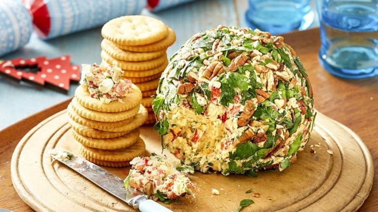 a cheese ball on a cutting board with crackers